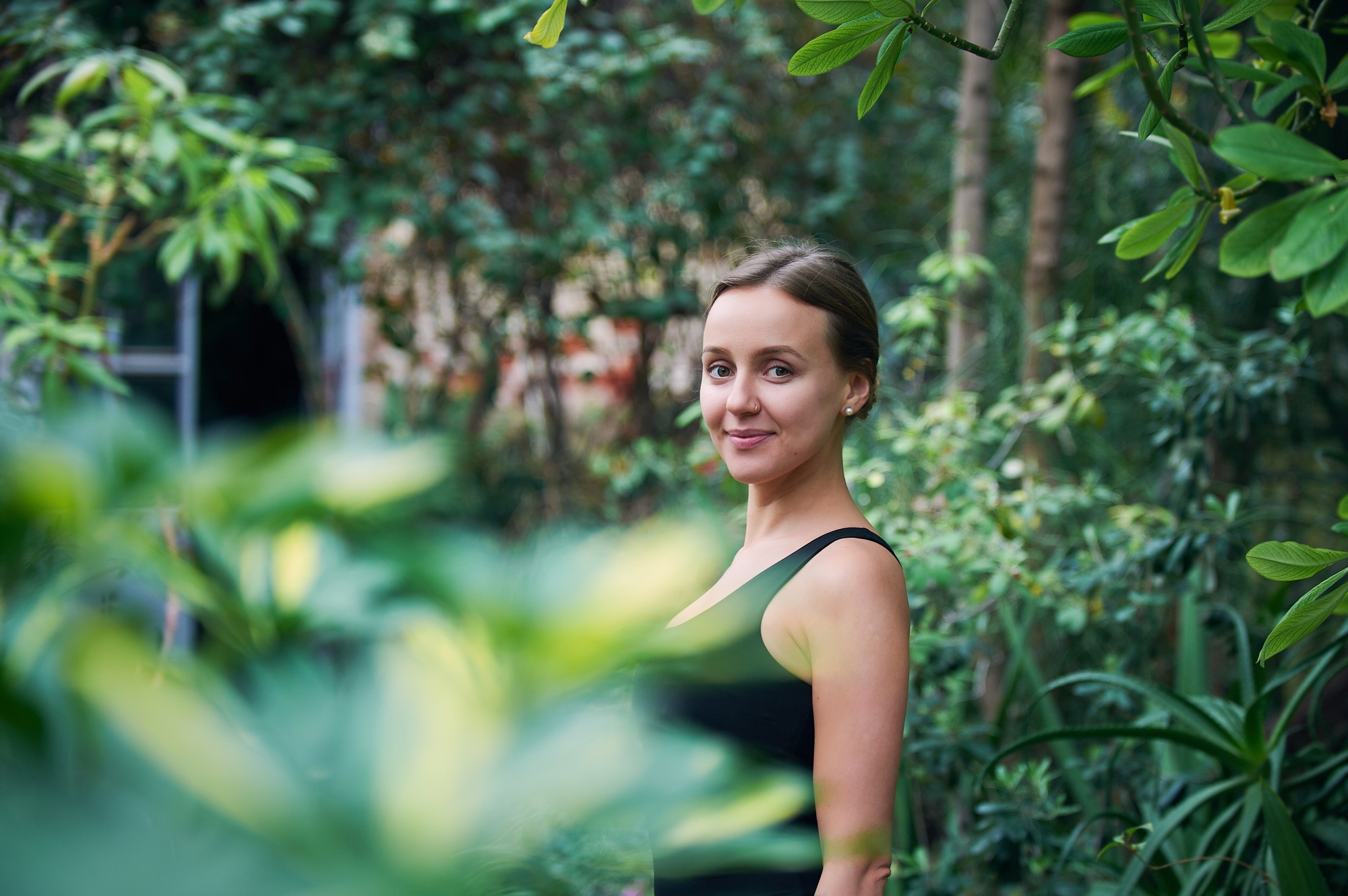 Portrait of cute young woman in jungle. Sunny day